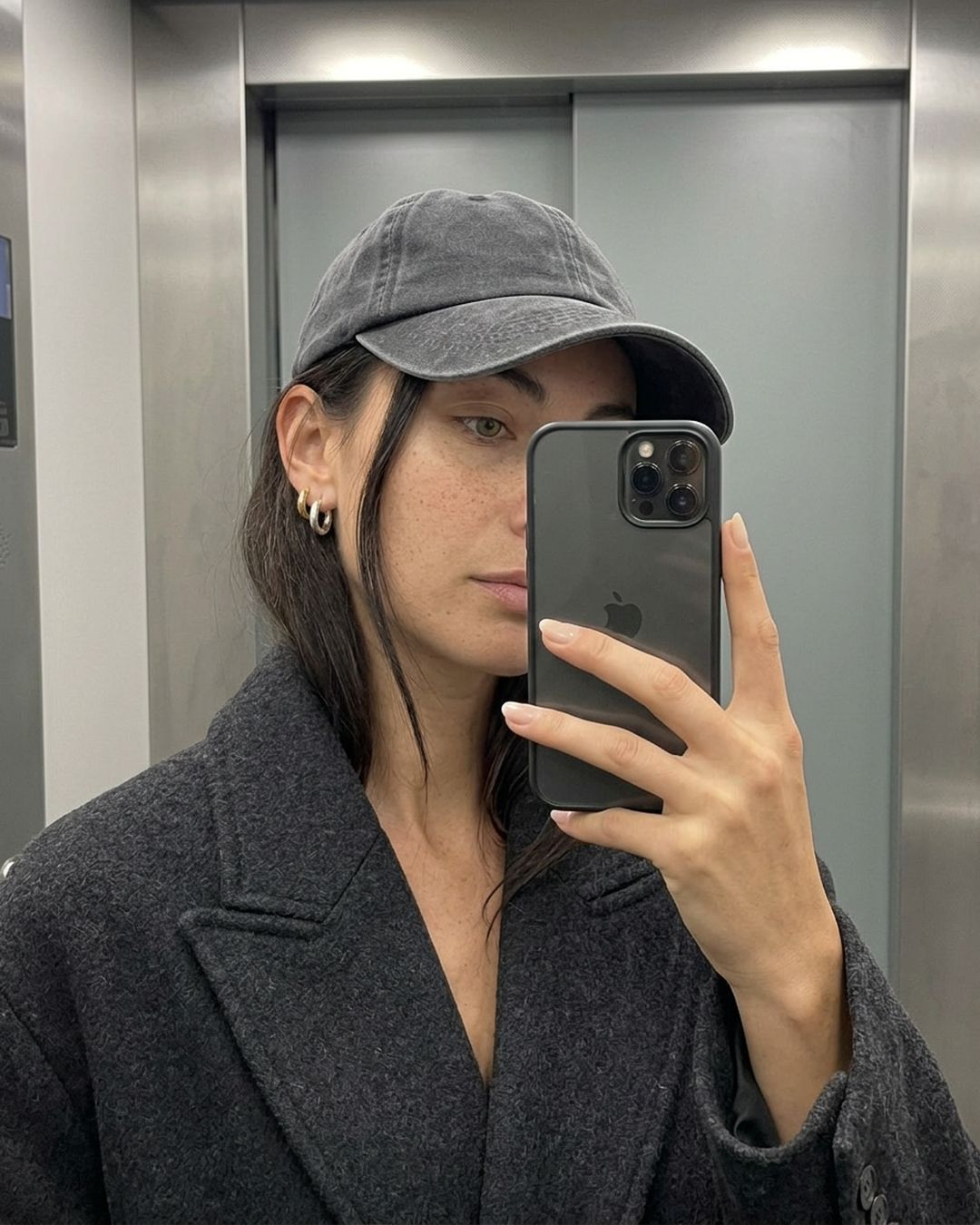 Zibá: selfie en el espejo con gorra y aros dorados